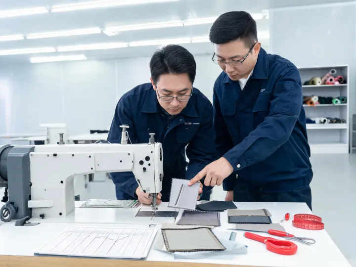 Technician and production engineer reviewing an industrial sewing machine sample